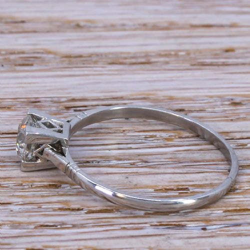 fig 2. An Art Deco diamond ring featuring a single old cut diamond set in a square metal mounting on a slender band.