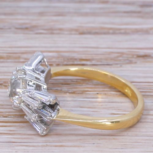 fig 2. A Mid-Century diamond ring featuring a central round old-cut diamond flanked by fanned tapered baguette cut diamonds on a yellow gold band.