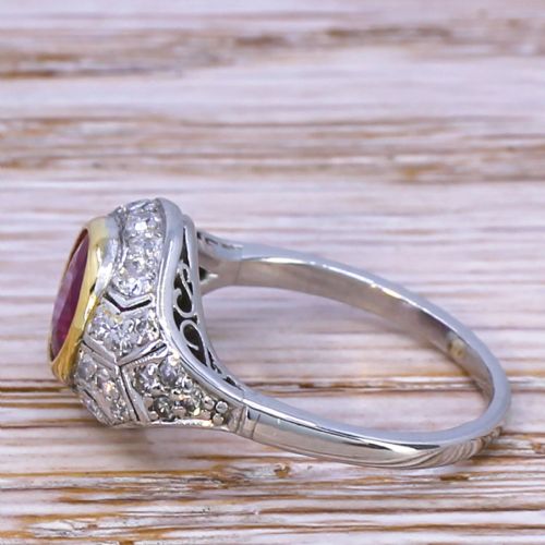 fig 2. An Art Deco ring featuring a round red ruby set in a gold bezel, framed by platinum geometric shoulders set with pave diamonds.
