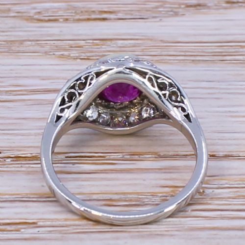 fig 3. An Art Deco ring featuring a round red ruby set in a gold bezel, framed by platinum geometric shoulders set with pave diamonds.