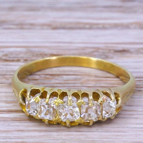 fig 1. A Victorian yellow gold ring featuring a horizontal setting of five old cut diamonds in an open carved gallery.