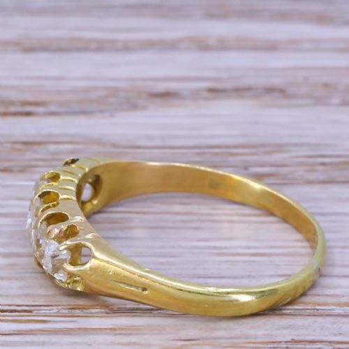 fig 2. A Victorian yellow gold ring featuring a horizontal setting of five old cut diamonds in an open carved gallery.