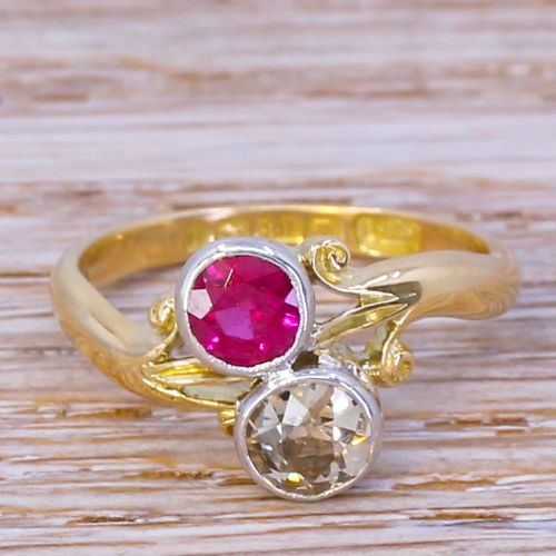 fig 1. An Edwardian yellow gold crossover ring featuring a bezel-set round red synthetic ruby paired with an old cut diamond.