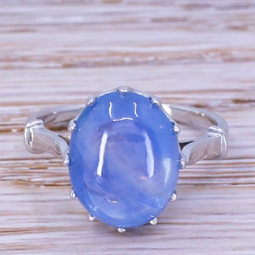 fig 1. An Art Deco platinum ring featuring a large oval blue cabochon sapphire held in a multi-claw setting.