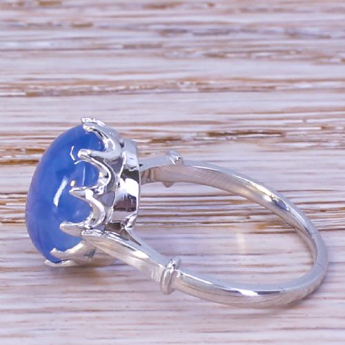 fig 2. An Art Deco platinum ring featuring a large oval blue cabochon sapphire held in a multi-claw setting.