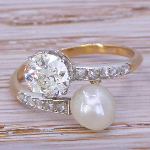 fig 1. An Edwardian yellow gold and platinum crossover ring set with an old-cut diamond and a natural white pearl alongside diamond-set shoulders.