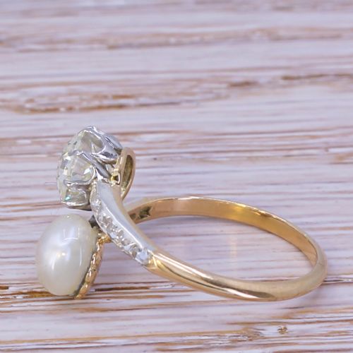 fig 2. An Edwardian yellow gold and platinum crossover ring set with an old-cut diamond and a natural white pearl alongside diamond-set shoulders.