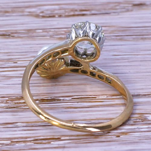 fig 3. An Edwardian yellow gold and platinum crossover ring set with an old-cut diamond and a natural white pearl alongside diamond-set shoulders.