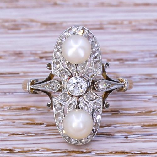 fig 1. An elongated Art Nouveau gold ring set vertically with two white natural pearls surrounded by rose-cut diamonds in an openwork mount.