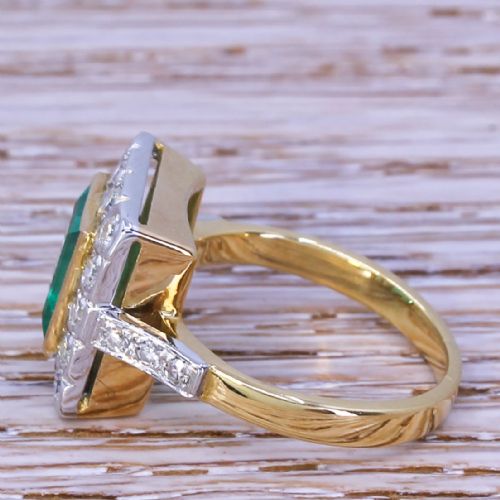 fig 2. An Art Deco ring featuring a rectangular emerald framed by a halo of diamonds set in platinum with a yellow gold band.