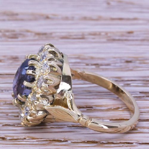 fig 2. A mid-century yellow gold cluster ring featuring an oval blue sapphire encircled by a halo of round diamonds.