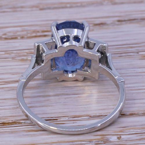 fig 3. A mid-century platinum ring featuring an oval cut blue Ceylon sapphire in a four claw setting flanked by rectangular diamond set shoulders.