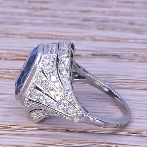 fig 2. An Art Deco platinum dress ring featuring an emerald cut blue sapphire surrounded by a geometric mounting set with small diamonds.