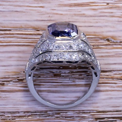 fig 4. An Art Deco platinum dress ring featuring an emerald cut blue sapphire surrounded by a geometric mounting set with small diamonds.