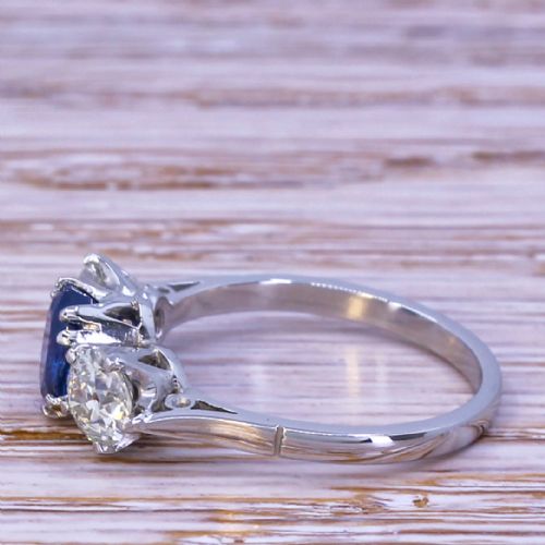 fig 2. An Art Deco trilogy ring featuring a central oval blue sapphire flanked by two round old cut diamonds set in platinum.