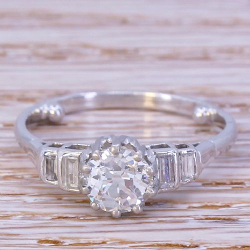 fig 1. An Art Deco platinum engagement ring featuring a central round old cut diamond flanked by stepped baguette diamond shoulders.