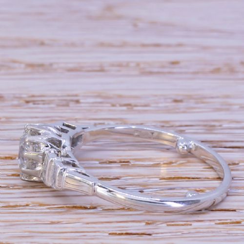 fig 2. An Art Deco platinum engagement ring featuring a central round old cut diamond flanked by stepped baguette diamond shoulders.