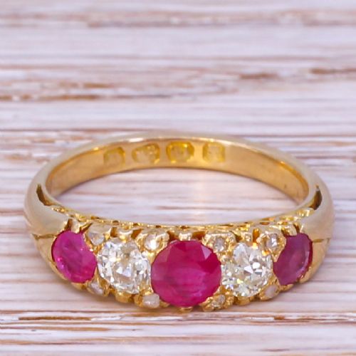 fig 1. An Art Deco yellow gold ring featuring three round red rubies alternating with two diamonds in a carved gallery setting.