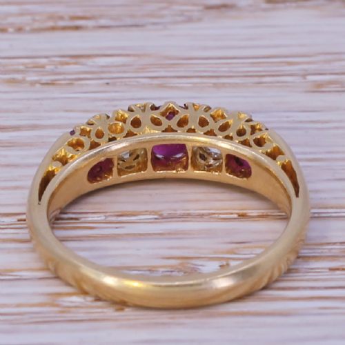 fig 3. An Art Deco yellow gold ring featuring three round red rubies alternating with two diamonds in a carved gallery setting.