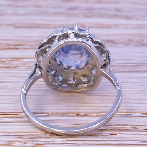 fig 3. An Art Deco ring featuring an oval light blue Ceylon sapphire centered within a scalloped halo of brilliant-cut diamonds on a platinum band.