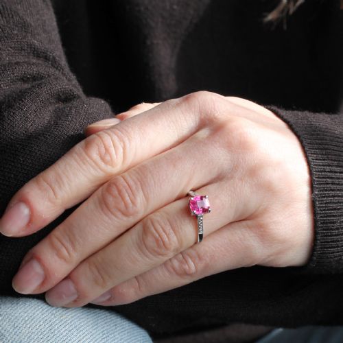 fig 1. A mid-century platinum solitaire ring featuring a central cushion-cut pink sapphire with small accent diamonds set into the shoulders.