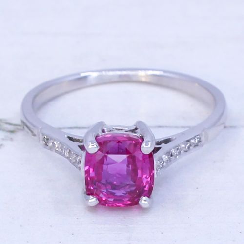 fig 2. A mid-century platinum solitaire ring featuring a central cushion-cut pink sapphire with small accent diamonds set into the shoulders.