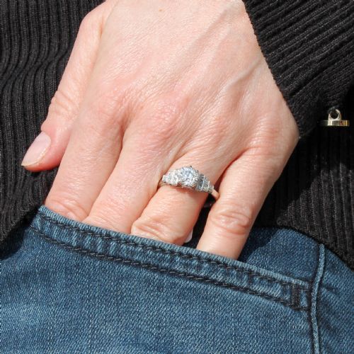 fig 1. An Art Deco platinum engagement ring featuring a central round old European cut diamond flanked by geometric stepped shoulders set with accent diamonds.