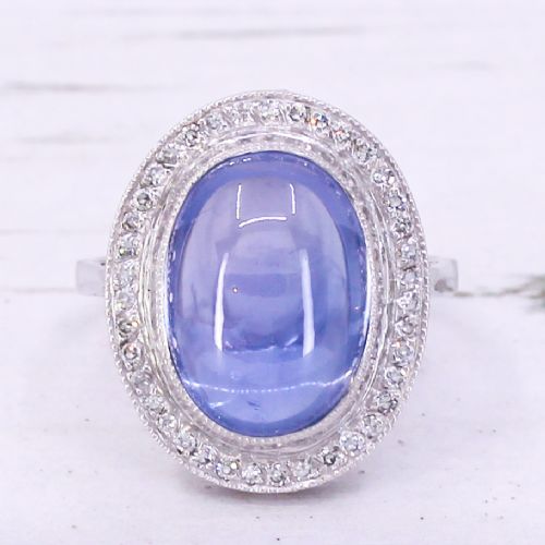 fig 2. An Art Deco ring featuring a large oval cabochon blue sapphire surrounded by a platinum frame set with small diamonds.