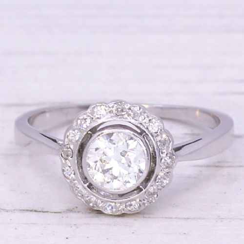 fig 2. An Art Deco diamond cluster ring featuring a central round diamond encircled by a halo of smaller diamonds on a white metal band.
