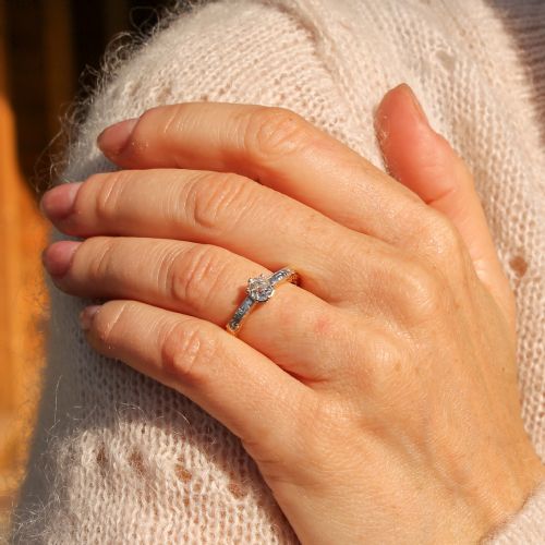 fig 1. An Edwardian yellow gold and platinum solitaire ring featuring a central old cut diamond set between hand-engraved scrollwork shoulders.