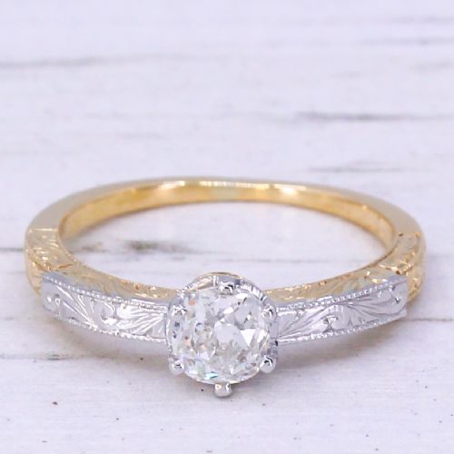 fig 2. An Edwardian yellow gold and platinum solitaire ring featuring a central old cut diamond set between hand-engraved scrollwork shoulders.