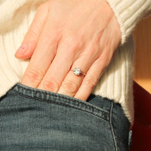fig 1. A mid-century platinum engagement ring featuring a central round transitional cut diamond secured in a multi-claw setting on a slender band.