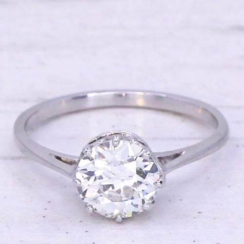 fig 2. A mid-century platinum engagement ring featuring a central round transitional cut diamond secured in a multi-claw setting on a slender band.