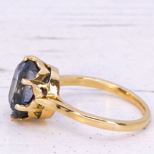 fig 3. A mid-century yellow gold solitaire ring featuring a large oval cut blue sapphire in a six-prong basket setting.