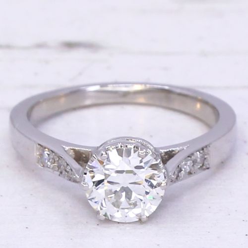 fig 2. An Art Deco platinum engagement ring set with a round old European cut diamond and accent diamonds along the shoulders.