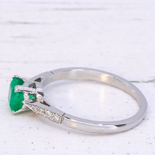 fig 3. An Art Deco ring featuring a square-cut green emerald solitaire set in a platinum band with small diamond shoulders.
