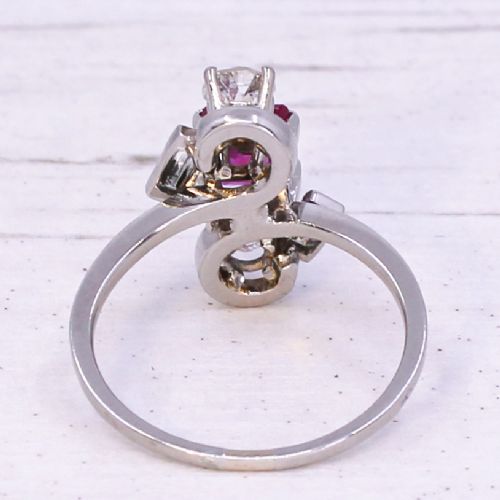 fig 4. An Art Deco platinum ring featuring a central rectangular pink-red ruby flanked by round and baguette cut diamonds in an asymmetric setting.