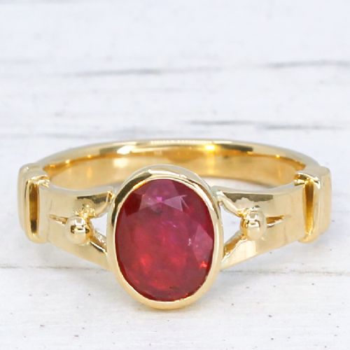 fig 2. A Victorian yellow gold solitaire ring featuring a centrally set oval red ruby with decorated shoulders.