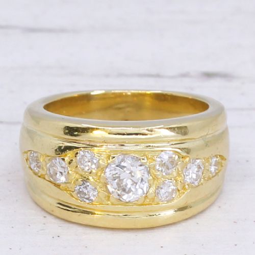 fig 2. A broad yellow gold band ring set with a cluster of round brilliant diamonds across the top surface.