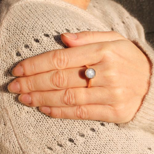 fig 1. A mid-century gold ring set with a bezel-mounted cabochon star sapphire gemstone displaying asterism.