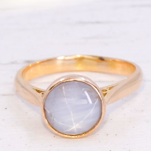 fig 2. A mid-century gold ring set with a bezel-mounted cabochon star sapphire gemstone displaying asterism.