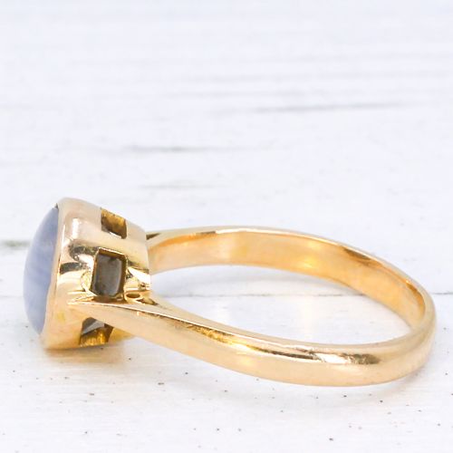 fig 3. A mid-century gold ring set with a bezel-mounted cabochon star sapphire gemstone displaying asterism.