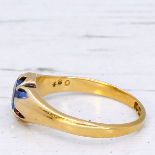 fig 3. An antique yellow gold ring featuring a central oval pale blue sapphire set in claw mountings with hallmarks engraved inside the band.