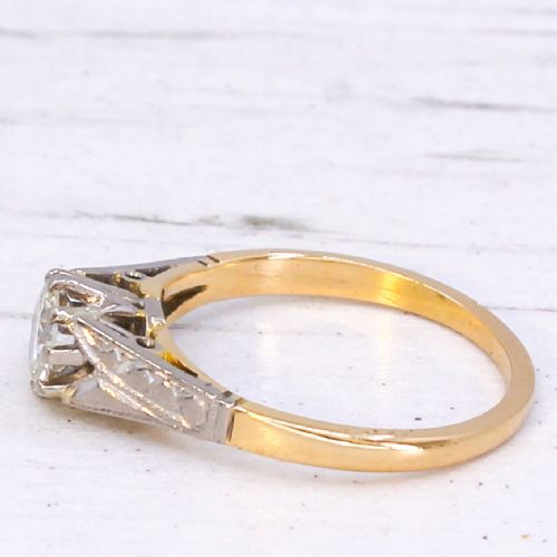 A vintage yellow gold solitaire engagement ring featuring a round brilliant cut diamond set in white metal claws with carved shoulders. View IV