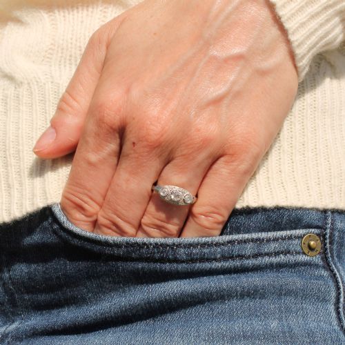 fig 1. A vintage Art Deco white metal ring featuring a central old cut diamond flanked by two smaller diamonds in an elongated milgrained setting.