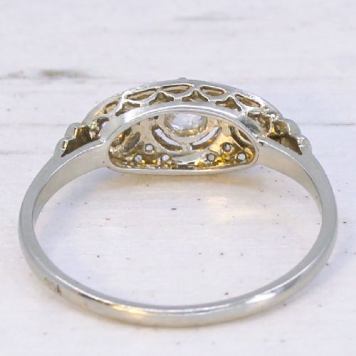 fig 4. A vintage Art Deco white metal ring featuring a central old cut diamond flanked by two smaller diamonds in an elongated milgrained setting.