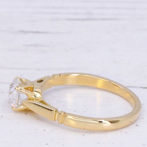 A yellow gold solitaire ring featuring a central cushion shaped old cut diamond with geometric shoulder accents. View IV