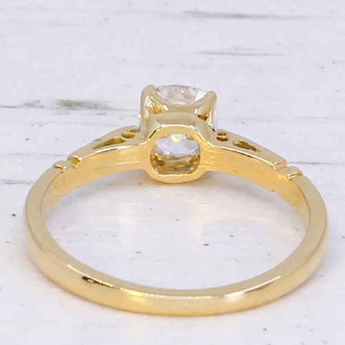 A yellow gold solitaire ring featuring a central cushion shaped old cut diamond with geometric shoulder accents. View V