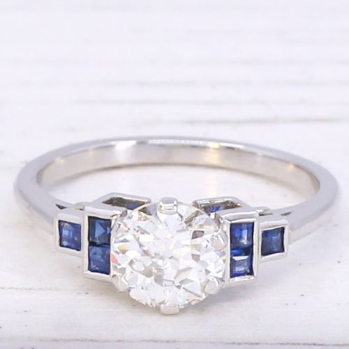 fig 2. A platinum ring featuring a central round old cut diamond flanked by stepped calibre-cut blue sapphires.