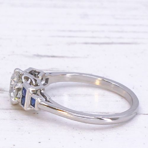 fig 3. A platinum ring featuring a central round old cut diamond flanked by stepped calibre-cut blue sapphires.